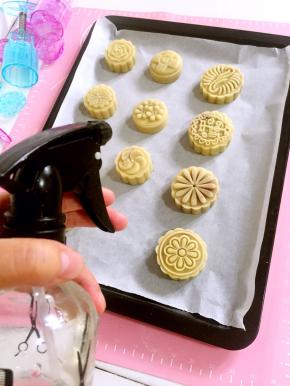 月饼全部按压好脱模之后，用喷雾瓶从高处薄薄的喷一层水雾在刚刚脱模好的月饼胚上，以免月饼在烤的过程中开裂！