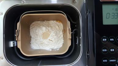 1．主料中除黄油外全部用料称量准确，放入面包机桶内，设定揉面程序。