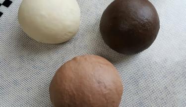 3．面团揉到扩展阶段取出平均分成三份，一份加入3克特黑可可粉一份，一份加入法芙娜可可粉2克，原色面团加入2克面粉揉匀至完全扩展阶段，进行基础发酵。