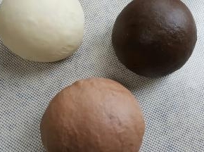 3．面团揉到扩展阶段取出平均分成三份，一份加入3克特黑可可粉一份，一份加入法芙娜可可粉2克，原色面团加入2克面粉揉匀至完全扩展阶段，进行基础发酵。