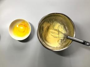 先加入一半的蛋黄，继续用手抽之字形充分混合。