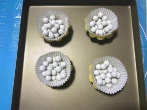 用叉子或牙签在挞皮底部扎一些小孔，铺上油纸，放入派石。