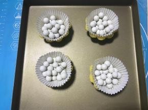 用叉子或牙签在挞皮底部扎一些小孔，铺上油纸，放入派石。