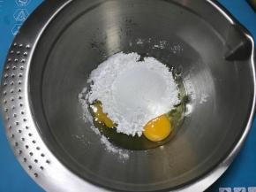 烤挞皮的时候准备挞馅，鸡蛋中加入糖粉，隔热水搅拌均匀。