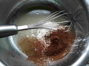 水和玉米油搅打均匀，筛入低筋面粉和可可粉、同时预热烤箱中层上下火180℃