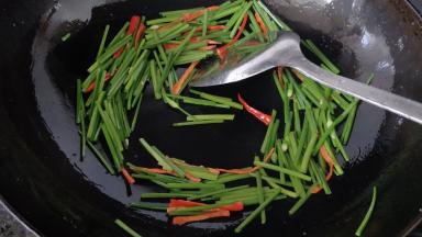 再放少许油烧热，下韭苔和红椒丝翻炒断生，加少许盐调味