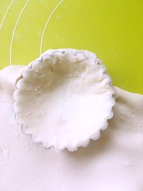 我用的蛋挞模具，擀好的面片铺在蛋挞模具里，用手轻轻压下蛋挞模具里，让面团装满，用力按一下边缘，裁掉多余的面团，记得留一点面团做网格