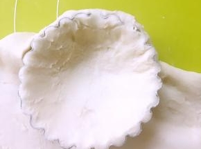 我用的蛋挞模具，擀好的面片铺在蛋挞模具里，用手轻轻压下蛋挞模具里，让面团装满，用力按一下边缘，裁掉多余的面团，记得留一点面团做网格