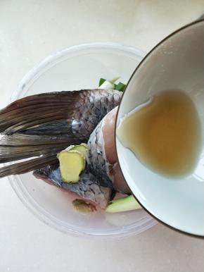 切断的鱼装入盆中，倒入搅拌好的酱汁