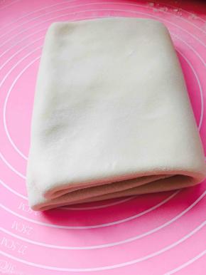 再延至中心位置对折，完成第一次折叠，包裹保鲜膜冷冻20分钟