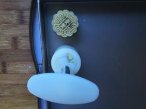 将月饼放入膜具中，向下压出形状