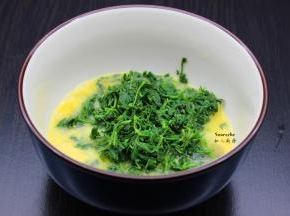 鸡蛋打散，把切碎艾叶、生姜末、盐放入鸡蛋碗盆中拌均；