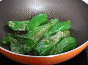 把青椒用锅铲一边压碎，一边翻炒至虎皮；