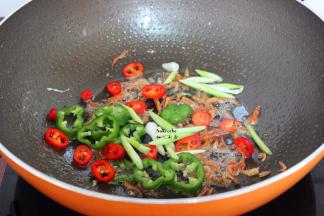 煎过鸡蛋的油锅小火煸香虾米、红辣椒、青辣椒、蒜白；