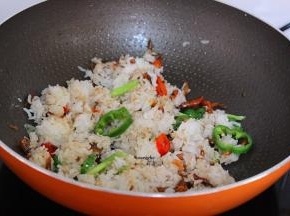 加入白砂糖，炒出糖色，放入蒸熟大米饭；