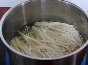 清水煮饭，放入金针菇汆汤熟；