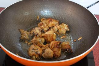 热锅，倒油，生姜煸炒鸡腿出油，放料酒、酱油炒至金黄色；