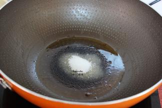 锅中留少许油，放入白砂糖煸炒出糖色；