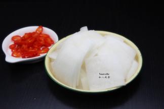 白萝卜去皮，切片，红辣椒洗净切好；PS：喜欢吃萝卜皮的可以不去皮。