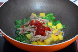 加入炒好的猪肉、番茄酱、白砂糖大火炒均；