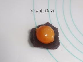 将称好的馅料搓圆压扁，我做了豆沙跟莲蓉两种馅料，放上咸蛋黄，用馅料把咸蛋黄包起，记住用虎口慢慢推，包裹均匀。最后揉圆。