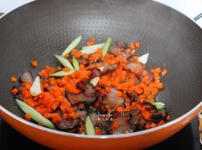 加入切好的胡萝卜粒、蒜苗，爆香即可起锅；