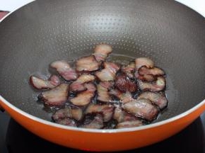 热锅倒油，小火煎腊肉，煎至微黄；