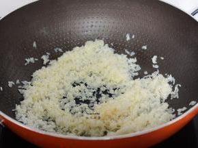 锅中放油，把腌制好的生米倒入翻炒至半透明状；