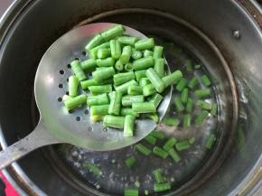 坐锅烧水，水开下红萝卜丁、豇豆丁焯熟。