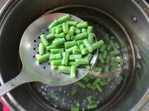 坐锅烧水，水开下红萝卜丁、豇豆丁焯熟。