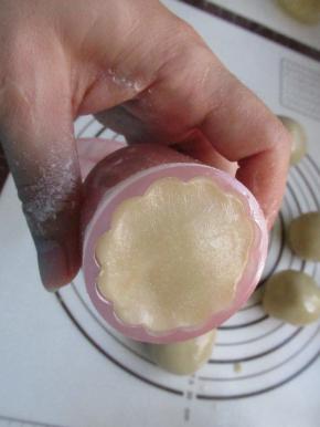 把月饼模具中撒点干面粉防粘，把包好馅的圆球放上。