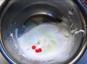 筛入玉米淀粉和奶粉，滴入两滴色素，用搅拌刀从下往上搅拌均匀，应快速，避免消跑