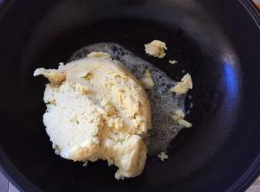 将绿豆沙放入锅中，翻炒，将黄油完全裹到绿豆沙中