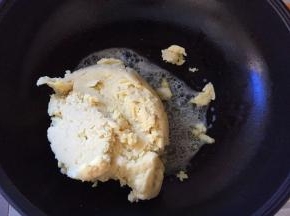 将绿豆沙放入锅中，翻炒，将黄油完全裹到绿豆沙中