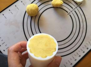 将绿豆沙放入膜具中，膜具中先摸点油，避免不好脱模，