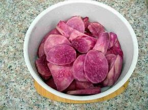 紫薯去皮切片，放入蒸笼里。