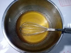 先做月饼皮。干净的容器中放入 50克玉米油，140克顺南的转化糖浆和4克枧水，搅匀，糖浆和油乳化好。