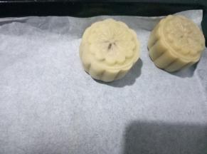 月饼模具朝下按，稍微用力，把月饼生坯扣出来，所有的月饼生坯都做好，排入金盘中。