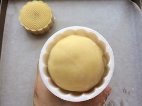 模具撒入适量的低粉，抖掉多余的粉，月饼团放入模具中轻轻用手中按压一下底部。