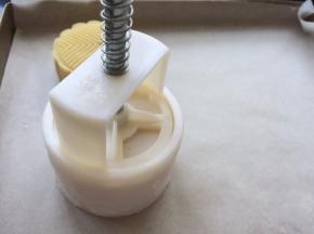 然后倒扣在烤盘中，轻轻按压下去，轻轻提起模具推出月饼。