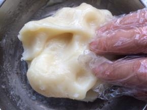 这时候冰皮已经蒸熟起锅，把冰皮拿出锅中，稍微放凉不烫手，手带上一次性手套把冰皮揉至光滑。