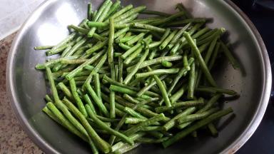 3.把豇豆段倒在锅中，大火煸炒。