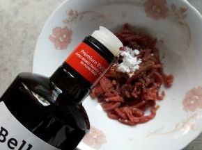 7.将牛肉条放在容器中，加生粉少许，黑胡椒粉少许，白砂糖少许，加适量的橄榄油和生抽进行调味。