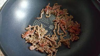 11.倒入肉丝进行煸炒。