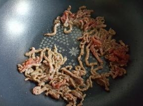 11.倒入肉丝进行煸炒。