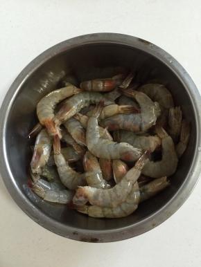 将虾放入碗中，加入2勺料酒去腥，再放2小勺盐增加底味。抓均匀后腌制15分钟。不用剥虾壳，这样更能锁住虾本身的鲜味。