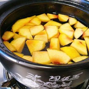 采用砂锅，将黄桃、冰糖、水放在一个无油的锅中煮开。