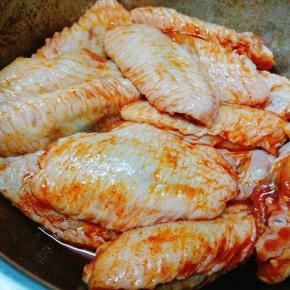 把鸡翅放入大碗中,用手抓匀后盖保鲜膜放冰箱冷藏腌制一夜