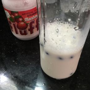 将蓝莓、牛奶放入料理杯。