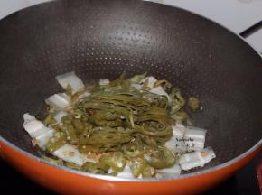 五花肉微黄，把肥肉的油炒出来，加入切好的酸辣椒；